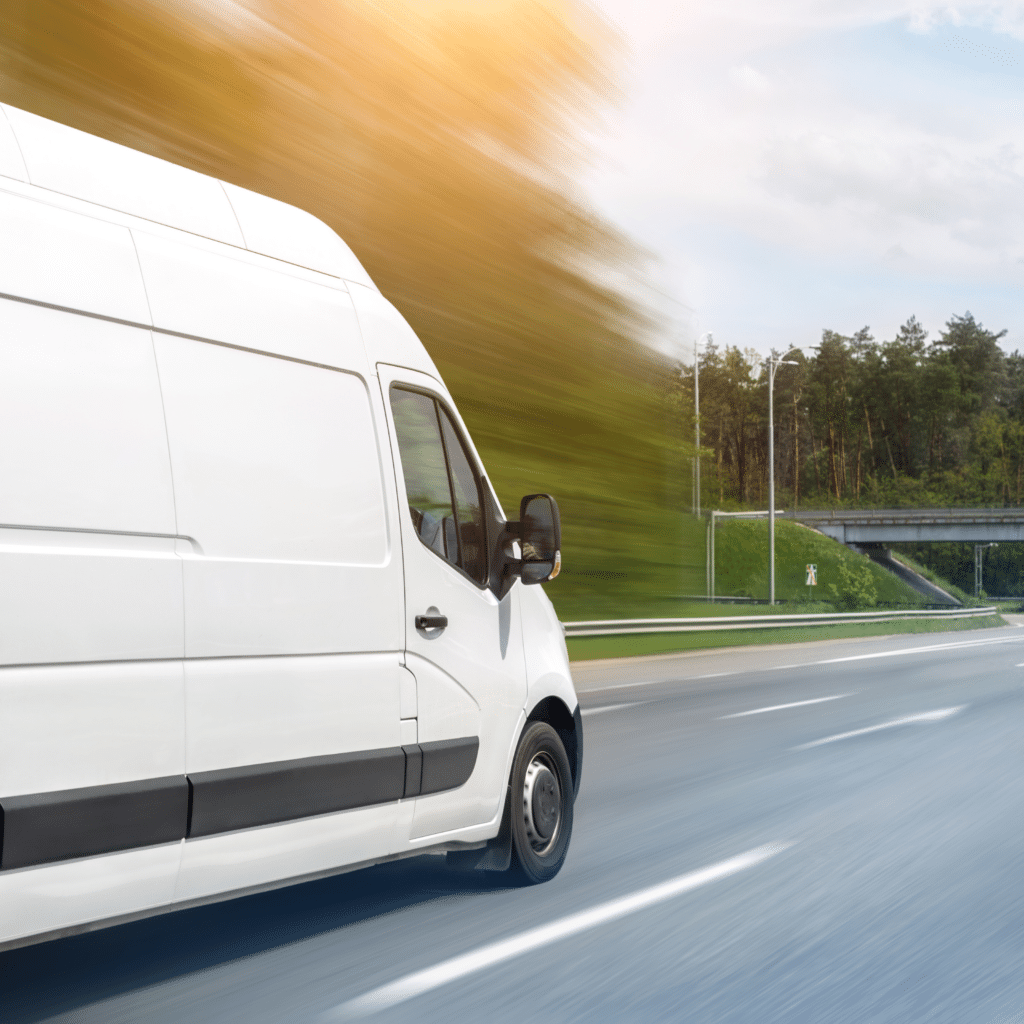 A white van travels on the motorway travelling quickly on the way to deliver items.